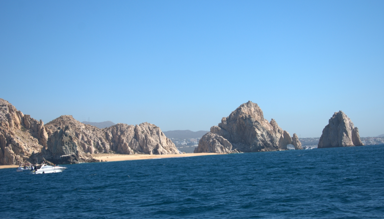 Aerial view of Lover's Beach at Land's End with a luxury yacht anchored in turquoise waters